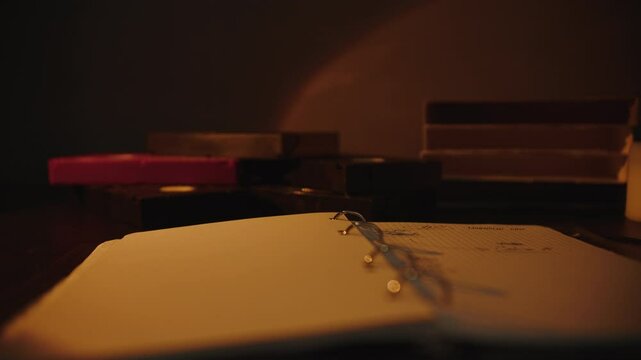 Stack of retro VHS tapes and open notebook in warm light