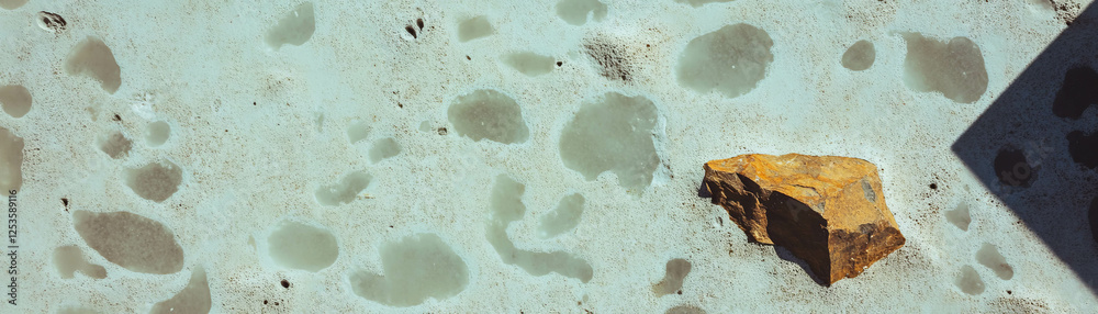Poster unique salt finished concrete with exposed aggregate and decorative texture under bright light
