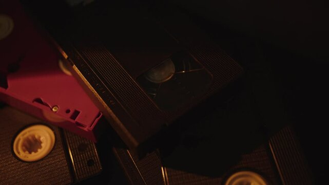Stack of retro VHS cassettes in moody light