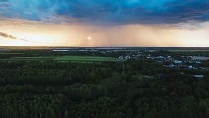 Storm clouds and sunset sky above countryside village