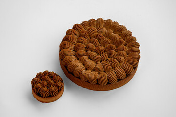 Close-up of a rich chocolate cream tart with delicate piping and a smooth ganache topping