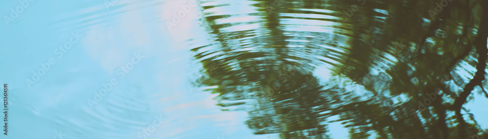 Poster Tree reflections create distorted shapes in calm water with a halftone texture