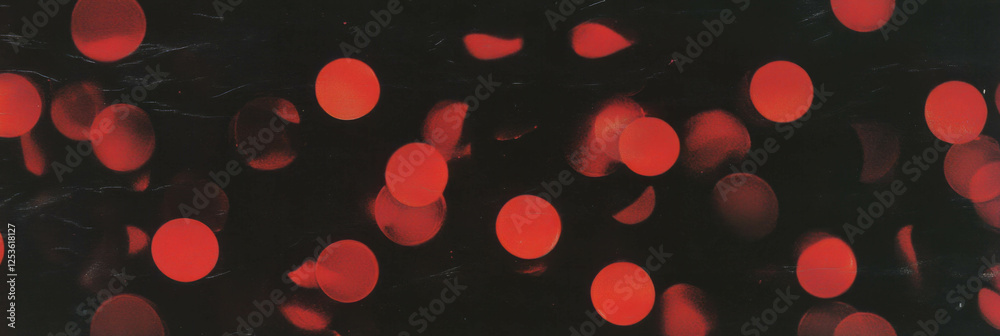 Aufkleber Dotted red flickers create an enchanting visual display against a dark background