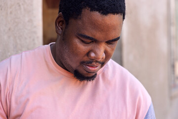Obraz premium African village, single young man with a goatee standing in front of his house, close portrait chubby body