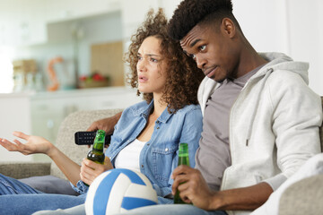 young couple watching a soccer match on tv