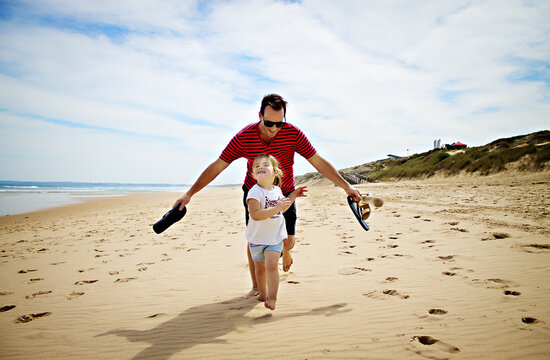 Happy Father and daughter running on the beach, Phillip Island, Victoria, Australia