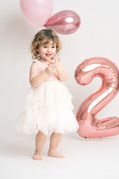 Kind M&auml;dchen 2 Jahre feiert ihren Geburtstag mit Ballons, wei&szlig;er Hintergrund isoliert im Studio Var. 3