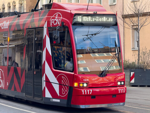 The new A red and white city tram, number 1117, with a "1 FCN" logo at Nuremberg, Germany - February 8, 2025