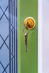 key in the front door of a house with others hanging from key-ring.