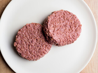 uncooked vegetarian bean burger patty on a white plate.