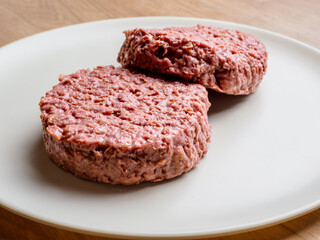 uncooked vegetarian bean burger patty on a white plate.