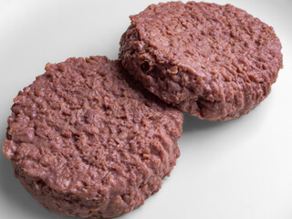 uncooked vegetarian bean burger patty on a white plate.