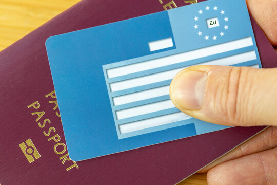 Travel insurance for Europeans traveling within the EU. Concept. Passport and European Health Insurance card held in hand. close up