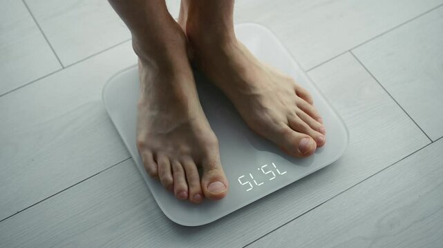 A man on a diet weighs himself on a scale.
A man is weighed during a medical examination.
A person finds out his weight.
Weight, diet, weight loss, sports, nutrition