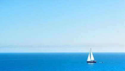 Fototapeta premium Sailboat gliding over calm blue waters under a clear sky