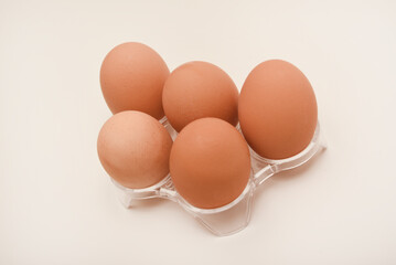 Chicken eggs in a roaster. A brown egg on a white background.