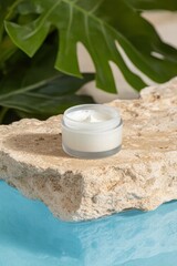 Creamy Moisturizer Jar on Textured Stone Surface with Greenery
