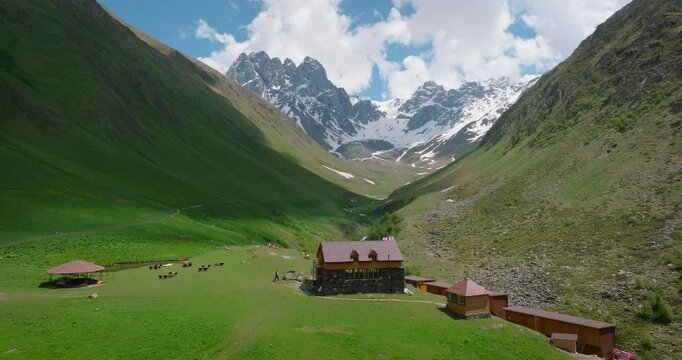 A drone moves from traditional village houses in the Juta Valley in the Kazbegi region of Georgia towards the Caucasus Mountains.