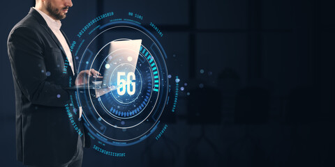 Businessman using laptop with digital 5G network interface on dark background.