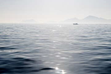 fishing boat with fog on the sea at dawn