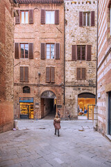Fototapeta premium Facade of old buildings in the historical center of Siena, the UNESCO World Heritage Centre, unchanged for 13-14 centuries, with its medieval streets looked like in the early Middle Ages. Italy, 2019