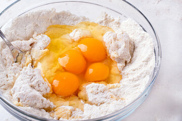 Adding raw eggs to yeast dough. Kneading rich dough for brioches, Easter cakes or buns