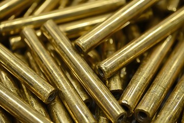 Brass Rods Texture: A close-up shot reveals a pile of gleaming brass rods, their smooth, golden surfaces catching the light, showcasing the intricate texture and metallic sheen. 