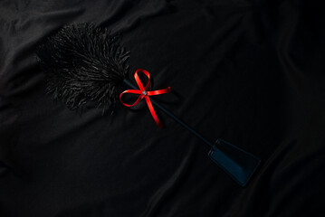 Whip for bdsm on a black background top view