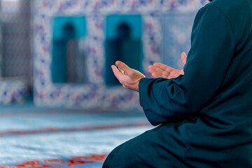 A captivating image of an imam praying after praying and reciting the Quran in a tranquil mosque,...