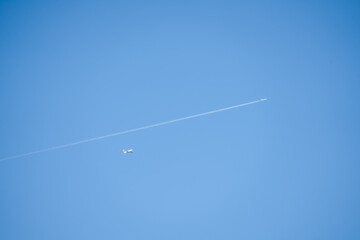 a pair of aeroplane jets a quad engine and twin engined jet liner aircraft in deep blue sky, contrails vapour trails