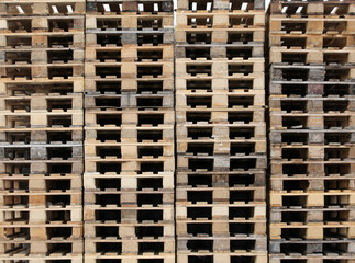 large pile of wooden pallets piled up in the empty warehouse of a freight forwarding company without the goods due to the economic crisis