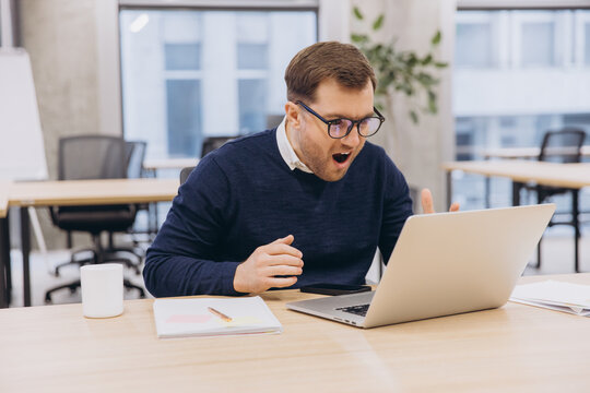 Surprised businessman looking at laptop in office with shocked facial expression, receiving unbelievable news - Powered by Adobe