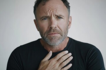 Fototapeta premium Man Experiencing Chest Pain with Hands Clutching Heart for Health Awareness Campaigns
