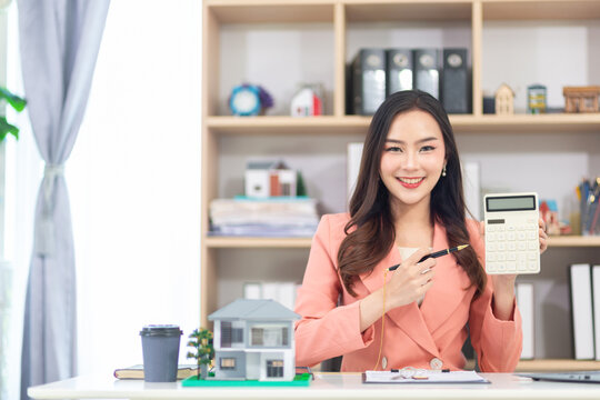 Asian woman real estate agent sitting in the office preparing documents. Businesswoman real estate agent because real estate business will continue to grow with the increasing population.