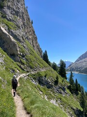 Femme en randonn&eacute;e dominant un lac d'altitude