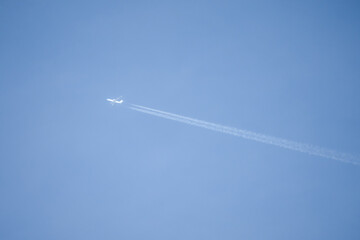 high altitude twin engine contrails (jet airplane vapour trails) across a deep blue clear sky