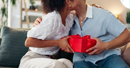 Couple, hug and gift on home for celebration, Valentines day and romantic gesture on sofa. Happy woman, man and box in lounge with birthday surprise, present or relationship milestone with thank you