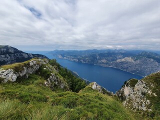 A verdant hillside provides a perfect vantage point to take in the expansive beauty of Garda Lake and its surrounding mountains.