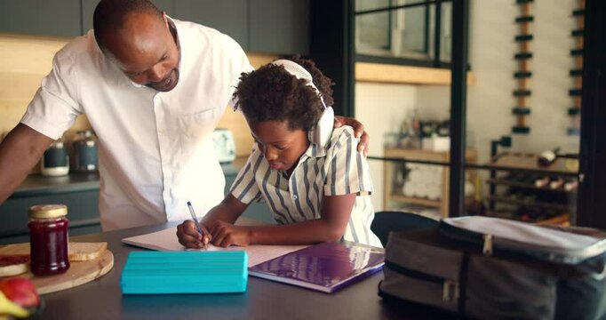 Homework, headphones and child with dad writing for remote learning, education and lesson. School, family and African boy with father in home with notebook for studying, knowledge and listen to audio