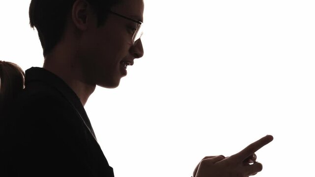 Couple silhouette. Romantic chat. Distance relationship. Dark profile of happy man using phone texting sending online air kiss to girlfriend isolated on white.