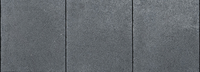 Close-up background of wall with dark gray cement panel texture and fine lines