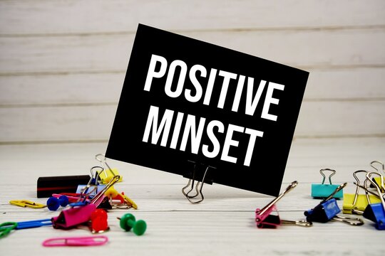 Positive Minset text on paper card with stationary on wooden background