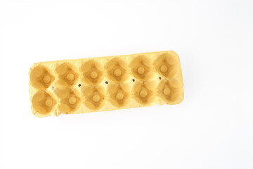 an empty, yellow, cardboard egg carton, top view on white background, part of creative process, supplies materials for paper craft, DIY project