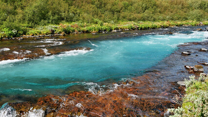 Blue river in green landscape in Iceland