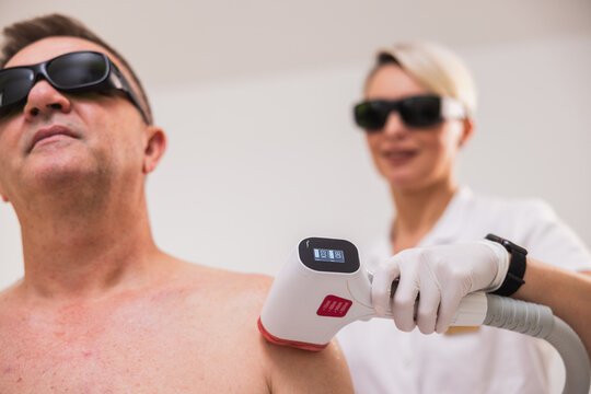Woman Doing Senior Man's Laser Hair Removal