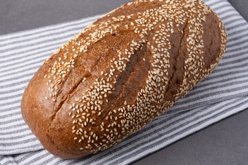 Freshly baked sesame bread resting on a striped cloth showcasing its golden crust and inviting aroma