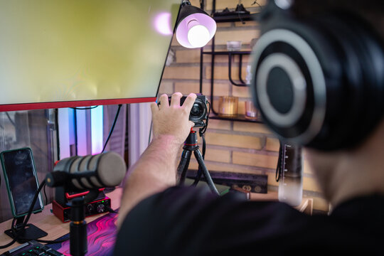 Gamer adjusting camera for live streaming, preparing streaming setup