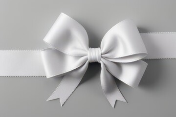 Naklejka premium Elegant White Satin Ribbon Bow on Gray Background: Gift Wrapping, Decoration, Celebration, Holiday, Wedding