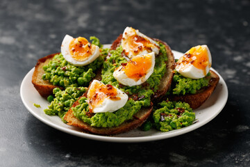 Smashed peas and egg sourdough toast with whole grain mustard sauce. Protein packed vegetarian food concept