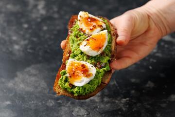 Smashed peas and egg sourdough toast with whole grain mustard sauce. Protein packed vegetarian food concept